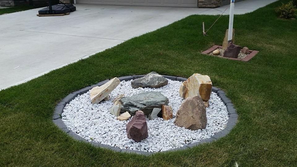Natural boulder and river rock water feature installation in residential yard